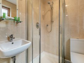 A bathroom with a sink, shower and toilet at Treehouse Spa in Perranporth