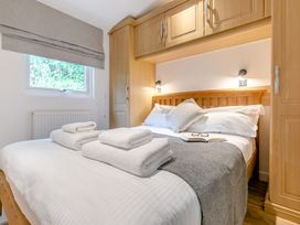 A bedroom with a bed, towels, and wardrobe at Morva Spa Pet in Perranporth