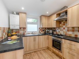 A kitchen with cabinets, sink, oven, and countertop at Morva Spa Pet Perranporth