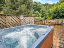 A hot tub in an outdoor area with a picnic table at Morva Spa Pet Perranporth