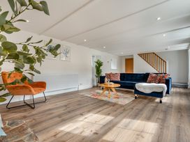 A living room with a sofa, chair, and coffee table at The Farmhouse (Pet) Perranporth