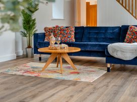 A living room with a blue sofa and a round coffee table at The Farmhouse (Pet) Perranporth