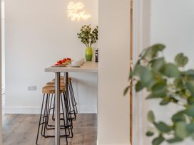 A kitchen with bar stools and a counter at The Farmhouse (Pet) Perranporth