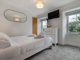 A bedroom with a bed and dresser at The Farmhouse (Pet) Perranporth