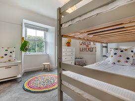 A bedroom with a bunk bed and toys at The Farmhouse (Pet) Perranporth
