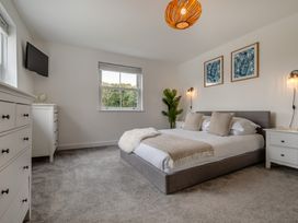A bedroom with a bed and dresser at The Farmhouse (Pet) Perranporth