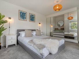 A bedroom with a bed and nightstands at The Farmhouse (Pet) Perranporth