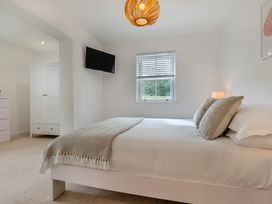 A bedroom with a bed and a television at The Farmhouse (Pet) Perranporth