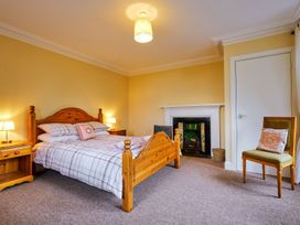 A bedroom with a bed and a fireplace at West Lodge in Kirriemuir