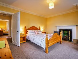 A bedroom with a bed and a nightstand at West Lodge in Kirriemuir