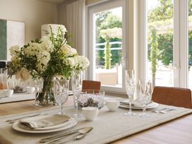 A dining room with a floral arrangement and tableware at Heatherwood (Pet) in Slaley