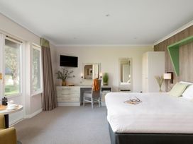 A bedroom with a bed, desk, and windows at The Hexham Spa in Slaley