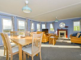 A living room with a dining area and television at Dartmoor View in Exeter
