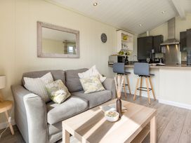 A living room with a sofa and kitchen counter at Stokesley (Pet) in Great Ayton