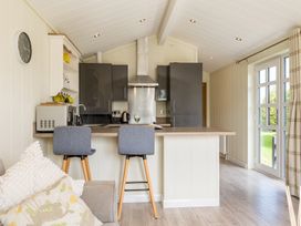 A kitchen with bar stools and modern appliances at Stokesley (Pet) Great Ayton