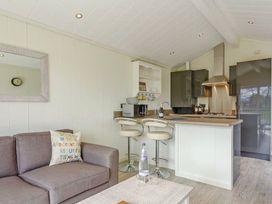 A kitchen with a sofa and bar stools at Stokesley (Pet) in Great Ayton
