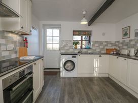 A kitchen with a washing machine and oven at Long Linney in Bideford