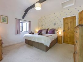 A bedroom with a large bed and wooden furniture at Long Linney in Bideford