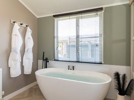 A bathroom with a bathtub and towels hanging at The Oasis in Great Ayton