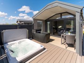 An outdoor patio with a hot tub and seating area at The Oasis in Great Ayton