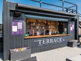 An outdoor bar with a menu board and shelves of alcohol bottles at The Dome in Great Ayton
