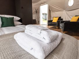 A bedroom with towels stacked on a bed at The Dome (Pet) Great Ayton