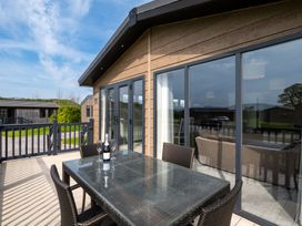 A dining table with chairs on a deck at Greystone in Great Ayton