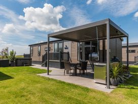 An outdoor area with a mobile home and seating at The Woods in Great Ayton