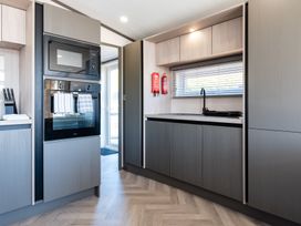 A kitchen with microwave, oven, sink and fire extinguishers at The Woods in Great Ayton