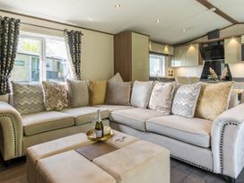 A living room with a sofa, cushions, and coffee table at The Woods (Pet) Great Ayton