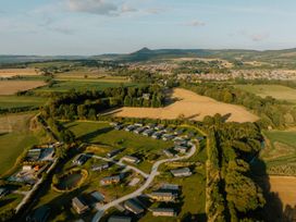 An aerial view of fields and houses near a hill at The Woods (Pet) Great Ayton