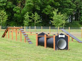 A dog agility course with ramps and tunnels in a fenced area at Roseberry in Great Ayton