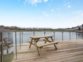 An outdoor area with a picnic table by the water at Tranquillity 3 (Pet) in Carnforth