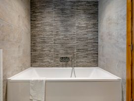 A bathtub with a faucet and wall tiles at Tranquillity 3 (Pet) in Carnforth