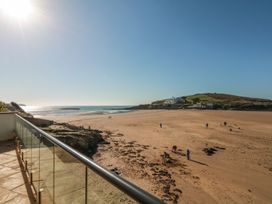 A beach view with people walking and a hill at 2 Burgh Island Causeway in Kingsbridge