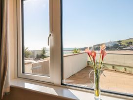 A window with flowers in a vase and a view of the beach at 2 Burgh Island Causeway Kingsbridge