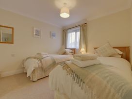 A bedroom with twin beds and a bedside lamp at 2 Burgh Island Causeway Kingsbridge