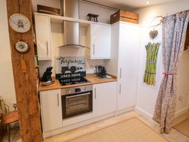A kitchen with cabinets and appliances at Flat 4 Evesham
