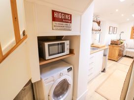 A kitchen with a microwave and washing machine at Flat 4 in Evesham