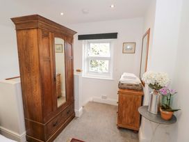 A bedroom with a wardrobe and flowers on a table at Flat 4 in Evesham