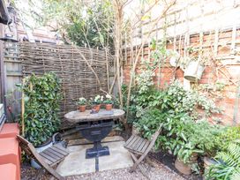 A garden with a table and chairs surrounded by plants at Flat 4 in Evesham
