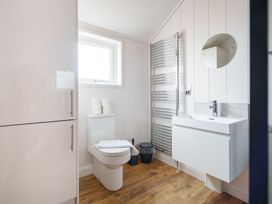 A bathroom with a toilet, wash basin and mirror at The Grays in North Berwick