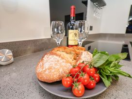 A plate with bread, tomatoes, and basil in a kitchen at The Homestead Moorsholm