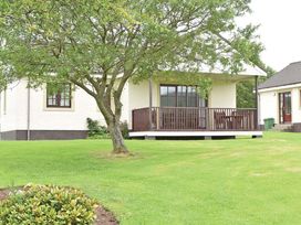 A house with a deck and tree in the garden at Bargany (Pet) Dailly
