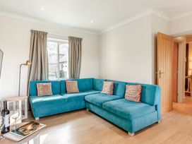 A living room with a blue sofa and a table at 4C2 Summerleaze Garden Cottage 2 Spa in Bude