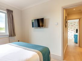 A bedroom with a bed and a television at 4C2 Summerleaze Garden Cottage 2 Spa in Bude