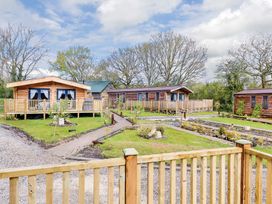 An outdoor area with cabins and landscaped gardens at Hurricane Lodge in Fair Oak