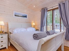 A bedroom with a bed and bedside table at Hurricane Lodge in Fair Oak