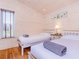 A bedroom with two beds and a bedside table at Hurricane Lodge Fair Oak