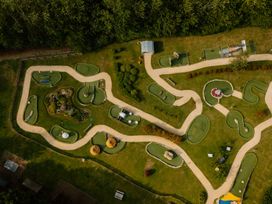 An outdoor mini golf course with greens and pathways at Hurricane Lodge in Fair Oak